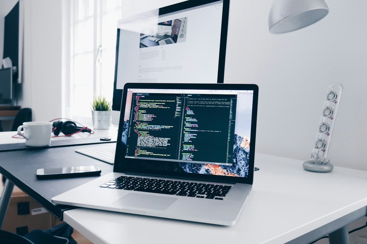 A designer's workspace blending code, wireframes, color swatches, and a circuit board