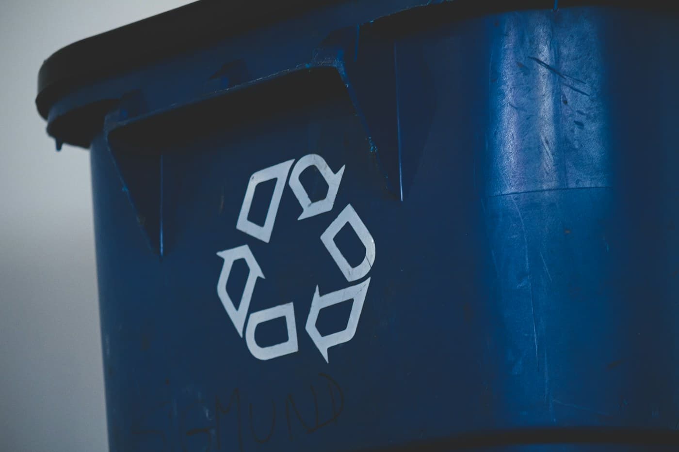White recycling symbol on a blue collection bin